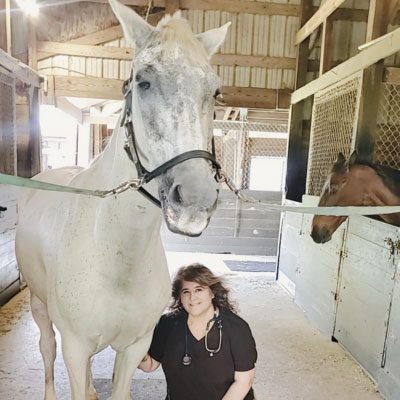 Dr. Maria Casillas with a white horse
