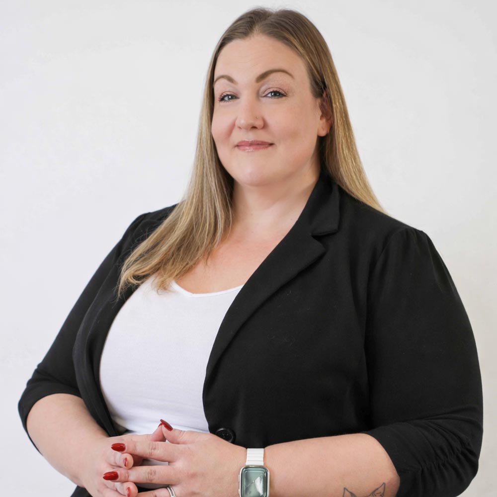 Amy Rapplean posing for a photo against a white wall