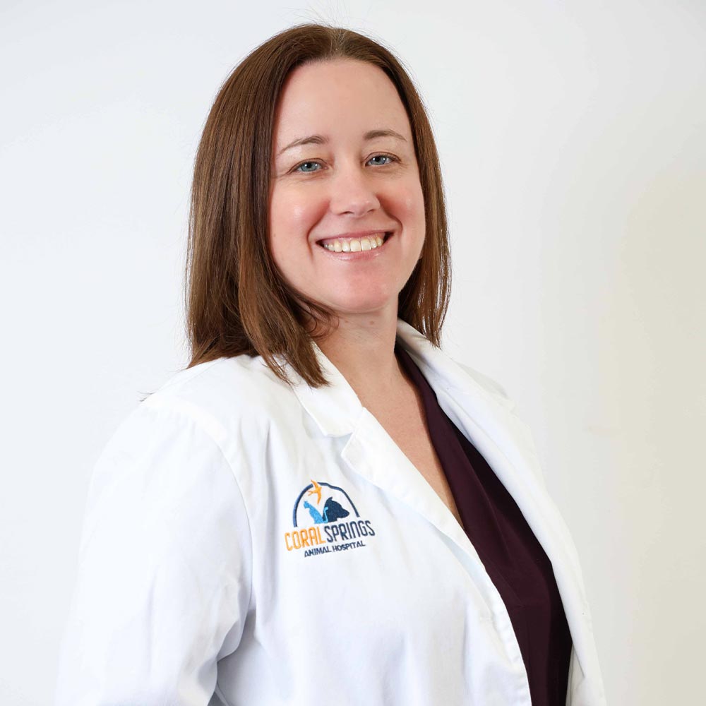 Dr. Amanda Benton posing for a photo against a white wall