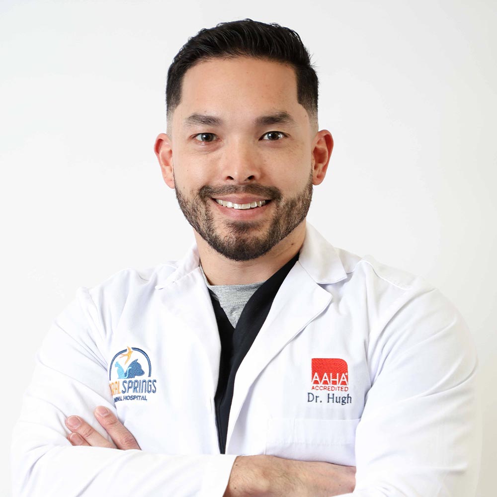 Dr Ryan Hugh posing for a photo against a white wall