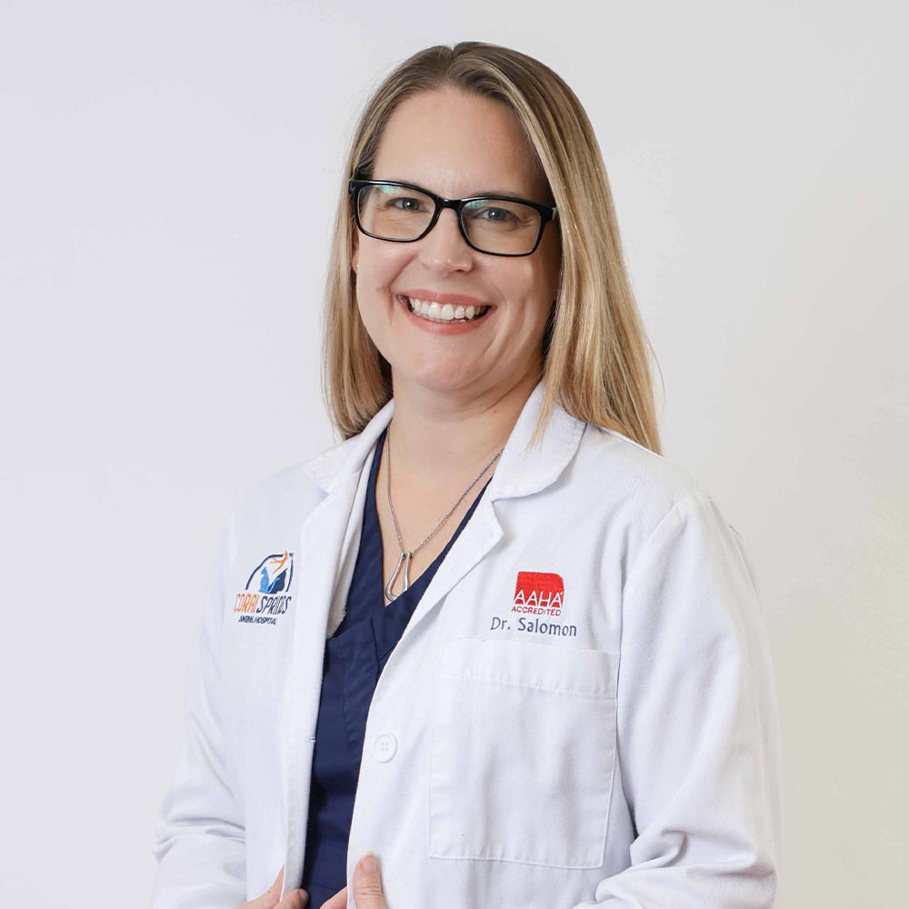 Dr Sara Salomon posing for a photo against a white wall