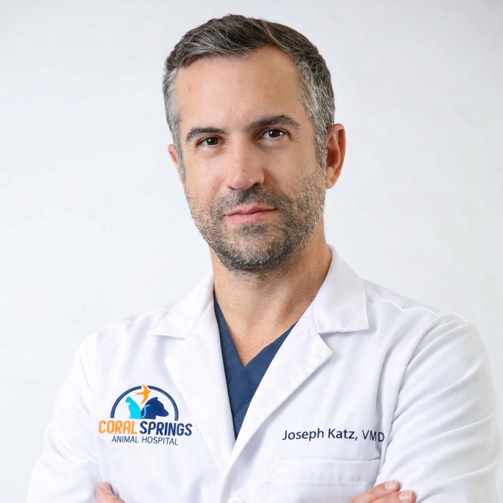 Dr Joseph Katz posing for a photo against a white wall